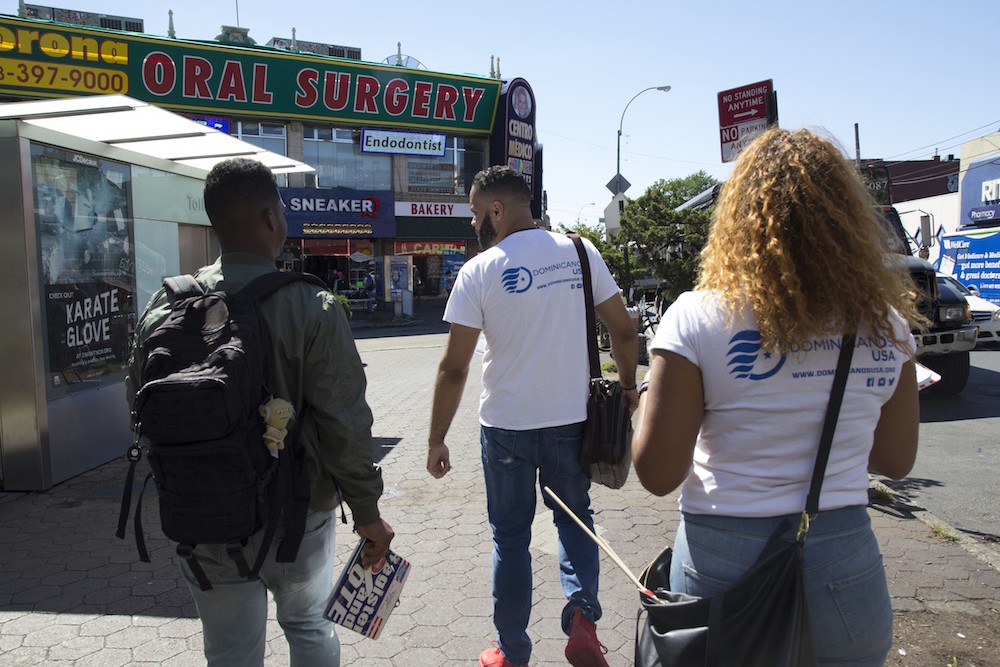 Canvassers from Dominicanos USA walk down the street in Corona, Queens. “We get to meet a lot of people and develop those bonds with the community,” says Yohan Diaz, left.